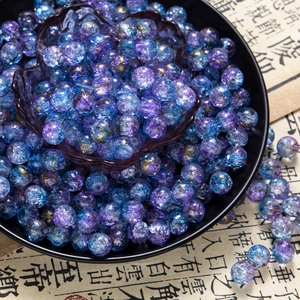 Detail of 10mm cracked glass beads with gold cloud patterns and blue-purple gradient