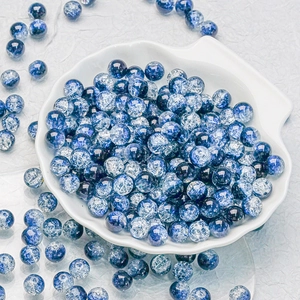 Macro detail of 10mm blue and white cracked glass beads on a shell-shaped tray