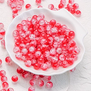 Macro shot of 10mm red cracked glass beads for DIY jewelry making in a shell bowl