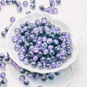 Macro shot of 10mm purple and grey cracked glass beads in a white shell dish for DIY jewelry