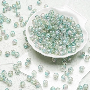 Detailed macro view of 10mm crackle glass beads in a white shell-shaped porcelain tray