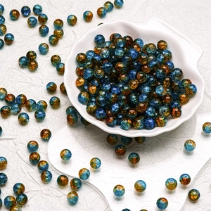 Macro detail of 10mm blue and amber glass beads with internal starburst ice textures