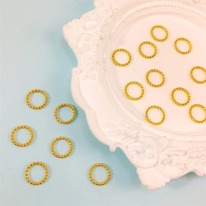 Vista macro de 16 anillos metálicos dorados trenzados para joyería DIY y conectores de cuentas
