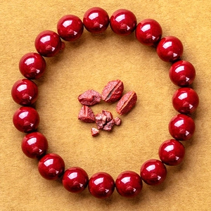Armband aus tiefroten Zinnober-Rundperlen mit rohen Mineralsteinen auf gelbem Hintergrund