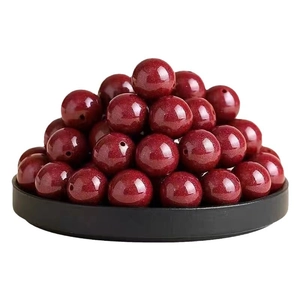 Dunkelrote Cinnabar-Stil Rundperlen mit Glitzereffekt auf schwarzem Displaytablett