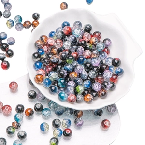 Mixed color 10mm crackle glass beads for jewelry making displayed on a shell tray