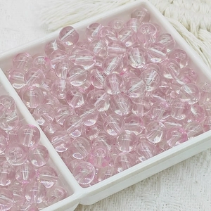 Perles en verre rose translucide pour bijoux DIY dans un plateau de tri blanc