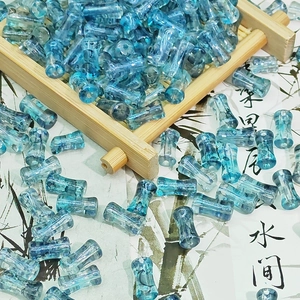 Détail macro de perles bleues translucides style bambou pour bijoux artisanaux