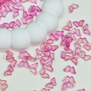 Macro shot of translucent pink glittery resin butterfly beads for DIY jewelry making