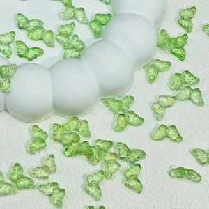 Detail of translucent green butterfly beads with gold foil for DIY jewelry making