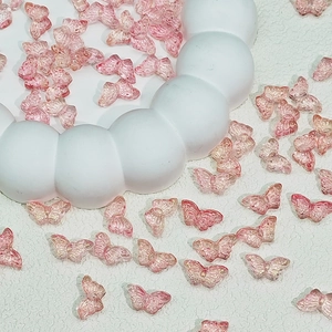 Macro shot of translucent pink butterfly beads for DIY jewelry with detailed wing textures