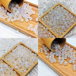 AB coated frosted and clear glass beads for DIY jewelry making in a wooden bowl