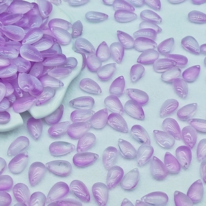 Macro shot of 8x14mm purple teardrop glass beads with holes for DIY jewelry making