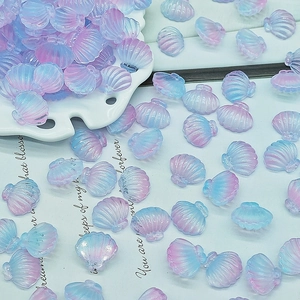Detailed view of iridescent pink and blue shell-shaped beads for DIY jewelry making
