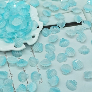 Macro shot of light blue translucent shell-shaped charms for DIY jewelry making