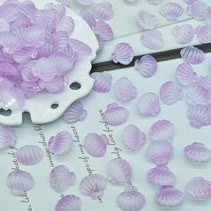 Macro detail of translucent purple shell-shaped resin beads for DIY jewelry making
