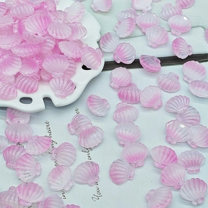 Macro shot of translucent pink gradient shell-shaped beads for DIY jewelry making