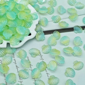 Detailed view of mint green and yellow gradient scallop shell beads with relief stripes