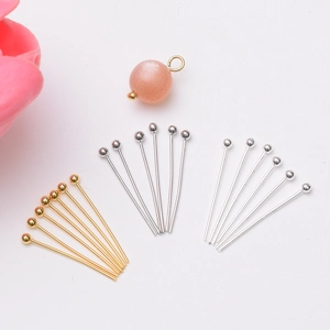 Detail of 14k gold-filled and silver ball head pins with a peach bead for DIY jewelry
