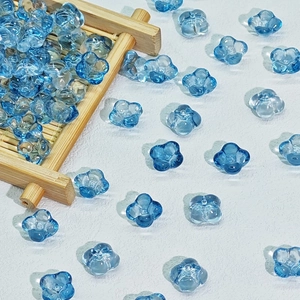 Macro detail of 10mm light blue translucent glass flower beads for DIY jewelry making
