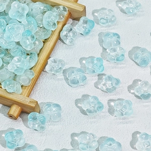 Macro detail of 10mm light blue transparent flower beads with a textured petal design