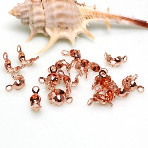 Gros plan des caches-nœuds en or rose et connecteurs à doubles boucles pour bijoux DIY