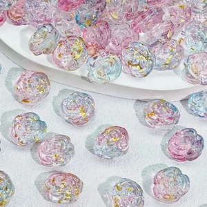 Makroaufnahme von Rosenperlen aus Glas mit Goldfolie und rosa-blauem Farbverlauf
