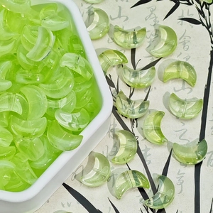Macro shot of pale green crescent glass beads for handmade jewelry DIY projects