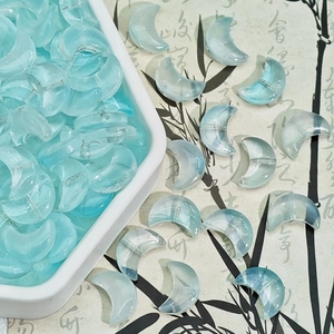 Close-up of translucent light blue crescent moon glass beads for DIY jewelry making
