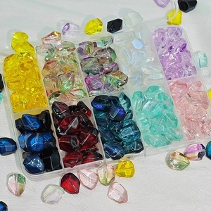 Macro view of colorful faceted glass beads in a clear 10-slot storage box for DIY jewelry