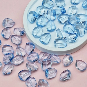 Macro view of translucent light blue and lilac faceted beads for DIY jewelry making