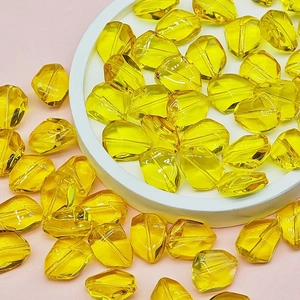 Macro shot of faceted bright yellow transparent resin beads for DIY jewelry making