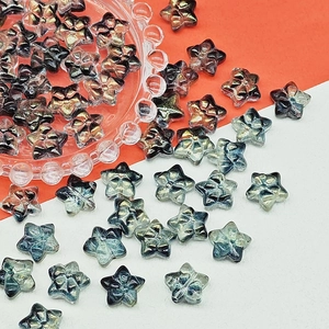 Macro shot of glass star beads with floral embossing and gradient metallic finish