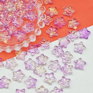 Macro detail of iridescent star-shaped beads for DIY jewelry with purple gold finish