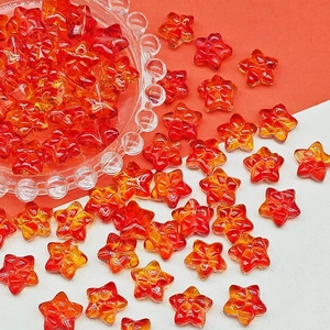 Close-up of star-shaped gradient glass beads with embossed plum blossom pattern for DIY