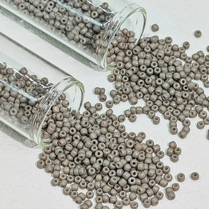Macro-opname van grijze ondoorzichtige glaskralen uit glazen buisjes voor DIY sieraden