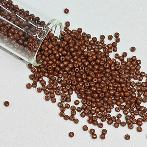 Macro-opname van bruine glazen kralen die uit een potje vallen voor DIY-sieraden maken