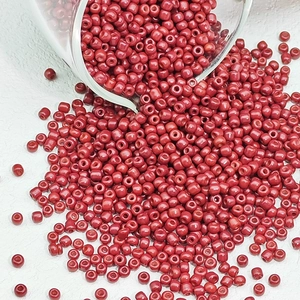 Macro-opname van rode glazen kralen die uit een pot gieten voor DIY-sieraden maken project