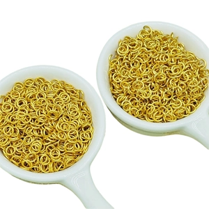 Matte gold jump rings for jewelry making shown in white ceramic spoons on white background