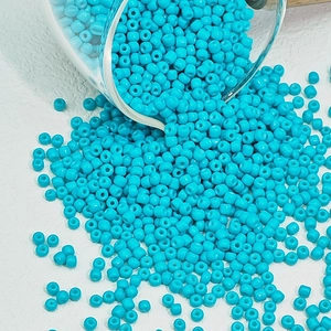 Macro-opname van turquoise glaskralen op witte achtergrond voor DIY-sieraden maken