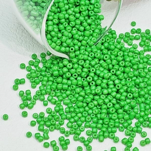 Macro-opname van levendige groene glaskralen die in een beker vloeien voor DIY sieraden