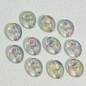 Flache Ansicht von 11 ovalen Glasperlen mit Rosenrelief und schillernder AB-Beschichtung