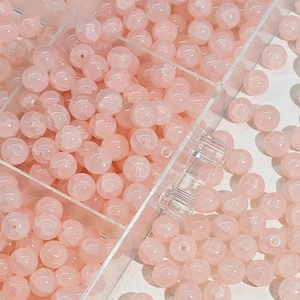 Detail van 10mm roze glazen kralen in een organizer voor het zelf maken van DIY-sieraden