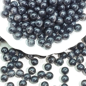 Macro view of polished black cat eye glass beads for DIY jewelry and bracelets