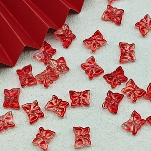 Deep red butterfly beads with gold glitter for handmade DIY jewelry on white texture background