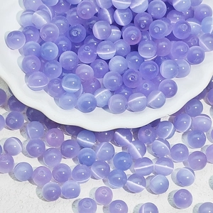 Detailed view of light purple cat-eye glass beads for DIY jewelry with threading holes