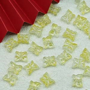 Macro shot of translucent yellow butterfly beads with iridescent pearl luster for DIY jewelry