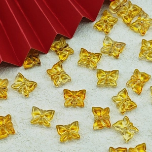 Detailed view of yellow transparent butterfly beads for DIY jewelry and necklaces