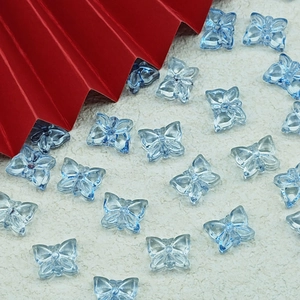 Macro detail of translucent light blue butterfly beads for DIY jewelry making