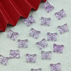 Macro detail of transparent purple butterfly charms for handmade jewelry and DIY crafts
